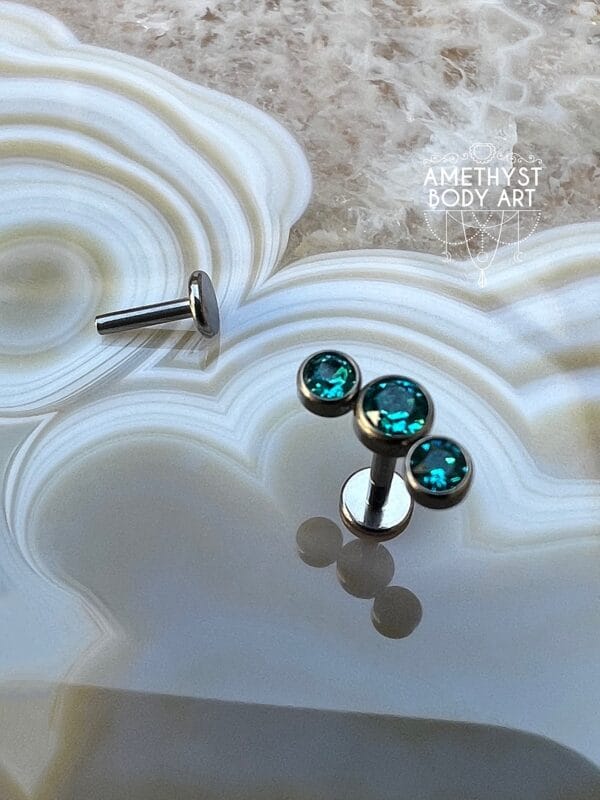 Cluster with 3 Bezel set Green CZ and Titanium Labret.
